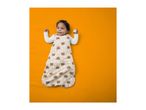 Baby in a beige sleeping bag with bear, moon, and star patterns, holding a wooden block.
