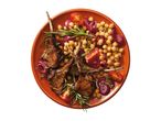 Grilled lamb chops with chickpeas, red onion, cherry tomatoes, and rosemary on a terracotta plate.