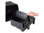 A hand removing the cooking basket from a Salter Dual View 7L Air Fryer.