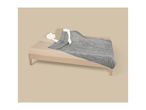 A person sleeping under a grey weighted blanket on a wooden bed.