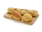 Une baguette, un petit pain kaiser et un autre petit pain sur une planche en bois.