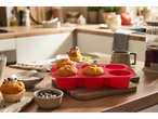 SILVERCREST® silicone muffin molds with baked muffins on a kitchen counter.
