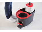 Conjunto de limpeza Vileda Easy Wring com esfregona e balde, ao lado de pés em jeans e sapatos brancos.