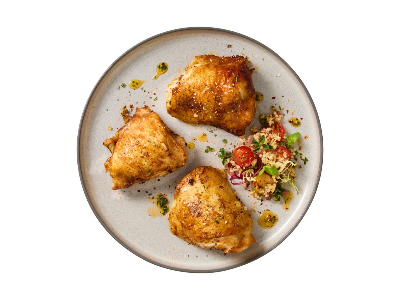 Three roasted chicken thighs with a side of couscous salad on a plate.