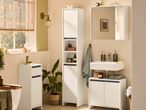 Bathroom with white storage cabinets, a sink, mirror cabinet, and a bathtub.