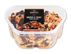 En klar plastbeholder fyldt med en blanding af nødder og tørret frugt, herunder jordnødder, cashewnødder, rosiner og kandiseret frugt.