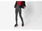 Femeie purtând jeggings modelatoare Esmara gri, un top roșu și o jachetă neagră, cu adidași negri.