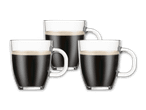 Drei klare Gläser mit schwarzem Kaffee und Schaum auf schwarzem Hintergrund.