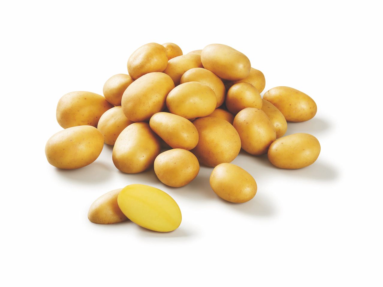 Un tas de pommes de terre jaunes, avec une coupée en deux au premier plan.