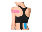 Woman with kinesiology tape on her shoulder and lower back, wearing a black sports bra.