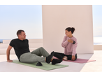 Two people on CRIVIT Yoga Mats, one using a massage ball, the other a massage tool.