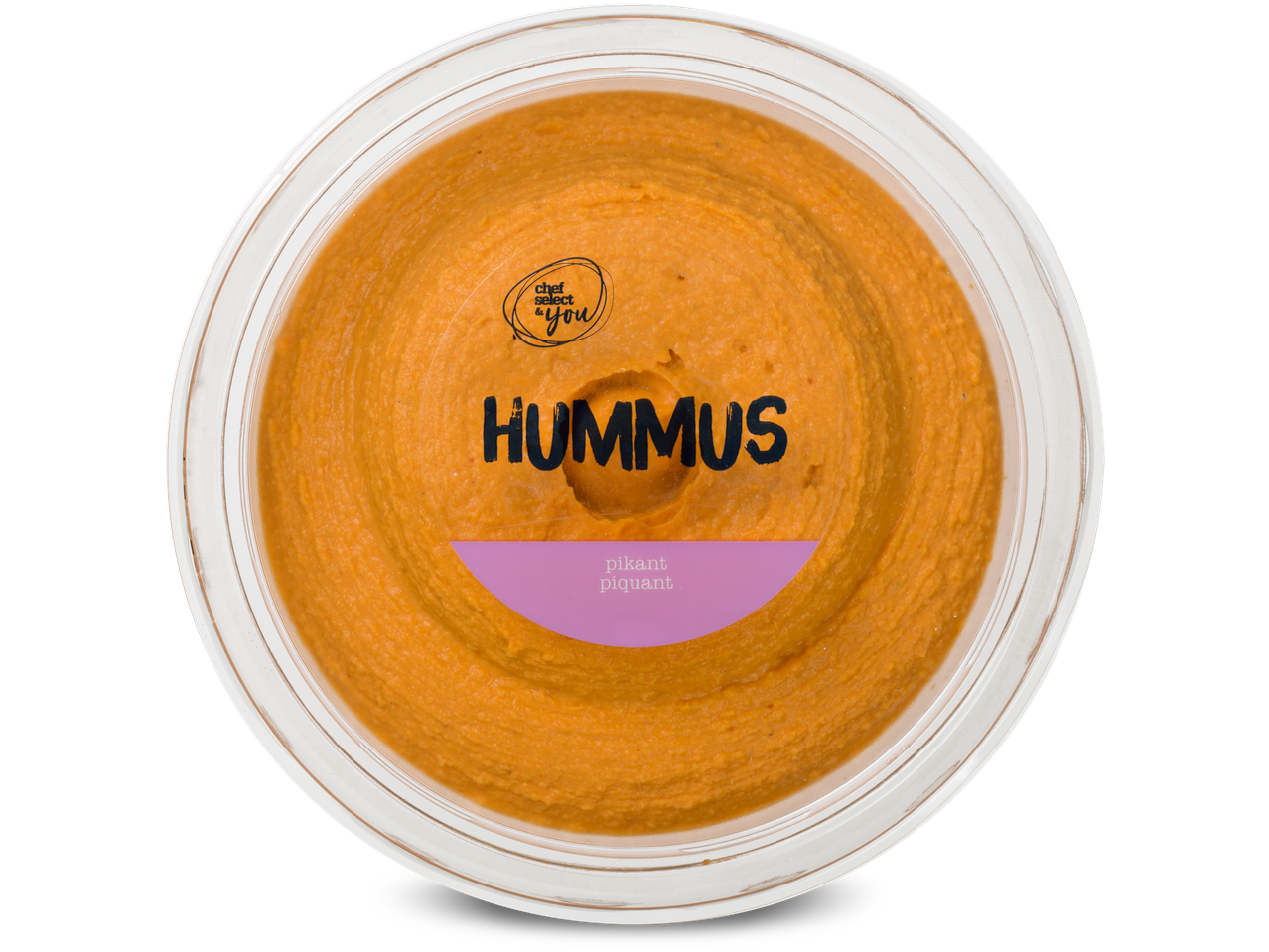Bovenaanzicht van een ronde bak oranje hummus met de tekst 'HUMMUS pikant piquant'