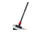 Close-up of a broom with a black handle and red connector, attached to a light-colored head.