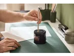 Ruka oštri olovku TRONIC električnim rezačem na zelenoj podlozi za sto.