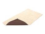 Beige bath mat with a textured rose pattern and a non-slip brown backing