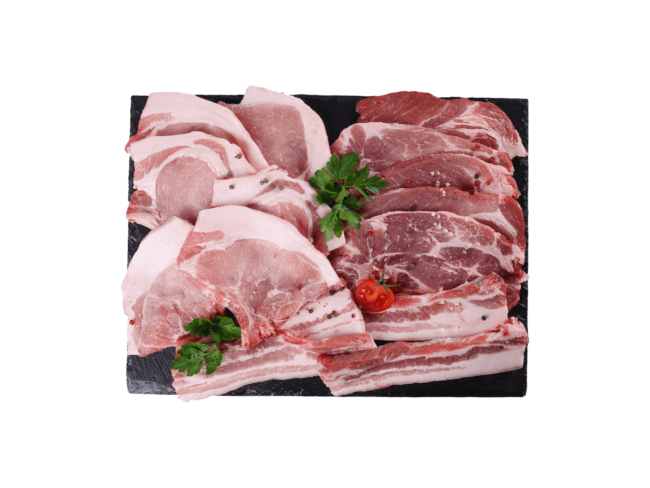 Sveže svinjsko meso: kotleti, vrat i slanina, začinjeno biberom i peršunom na crnoj ploči.