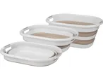 Tre cesti pieghevoli in plastica bianca e beige, di diverse dimensioni, impilati.