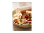 A plate of powdered sugar-dusted Swiss roll slices with raspberries and a fork.