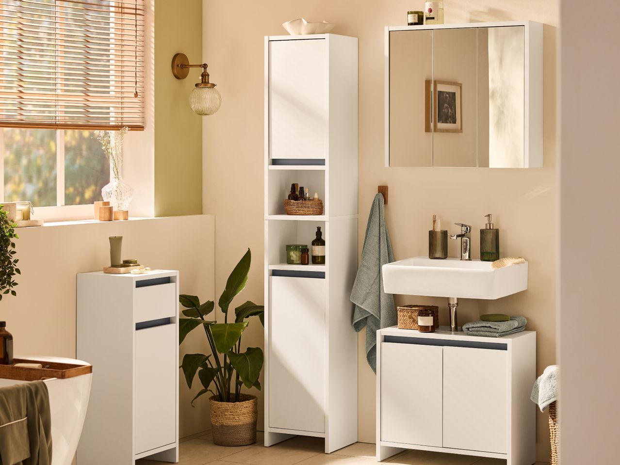 Bathroom with white storage cabinets, a sink, mirror cabinet, and a bathtub.