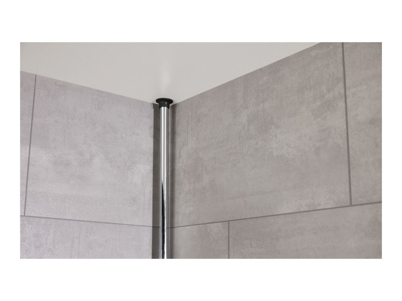 Close-up of a black shower rod installed in a corner, against grey tiles.