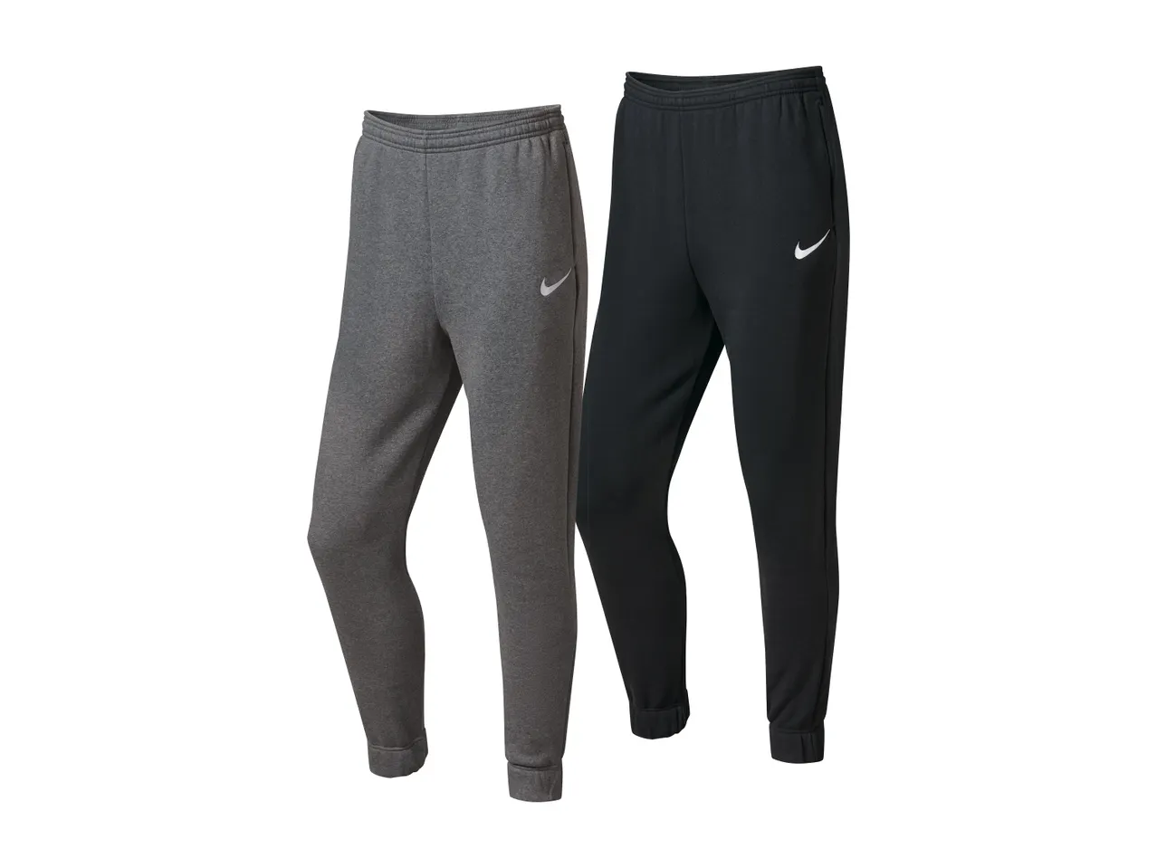 Dve moški trenirki Nike, ena siva in ena črna, na belem ozadju.