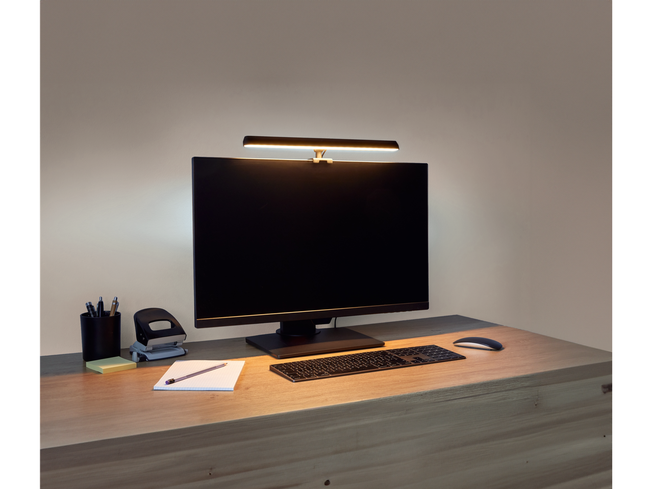 Livarno Home LED-Monitorleuchte beleuchtet einen Schreibtisch mit Computer, Tastatur und Maus.