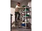 Homem num escadote dobrável Parkside® de 3 degraus, arrumando ferramentas numa prateleira.