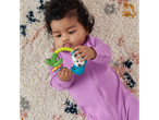 Baby in purple romper playing with a colorful sloth rattle on a patterned rug.