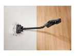 Cordless vacuum cleaner cleaning dirt on a white rug next to wooden flooring
