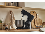 A black SilverCrest stand mixer with a stainless steel bowl on a kitchen counter.