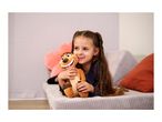 A young girl with pigtails smiles while hugging a plush toy on a sofa.