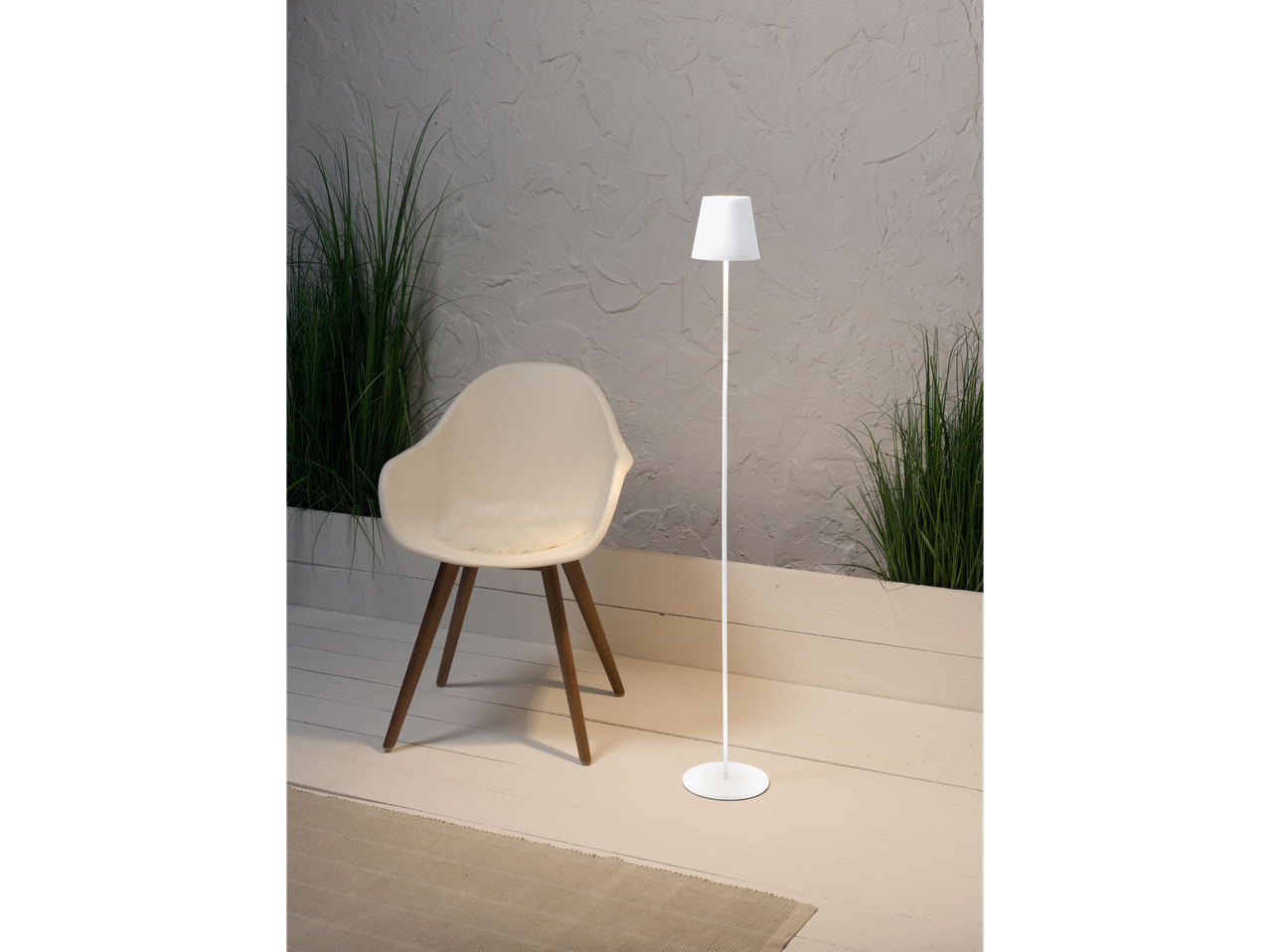 Moderne witte staande lamp en stoel met wollen kussen.