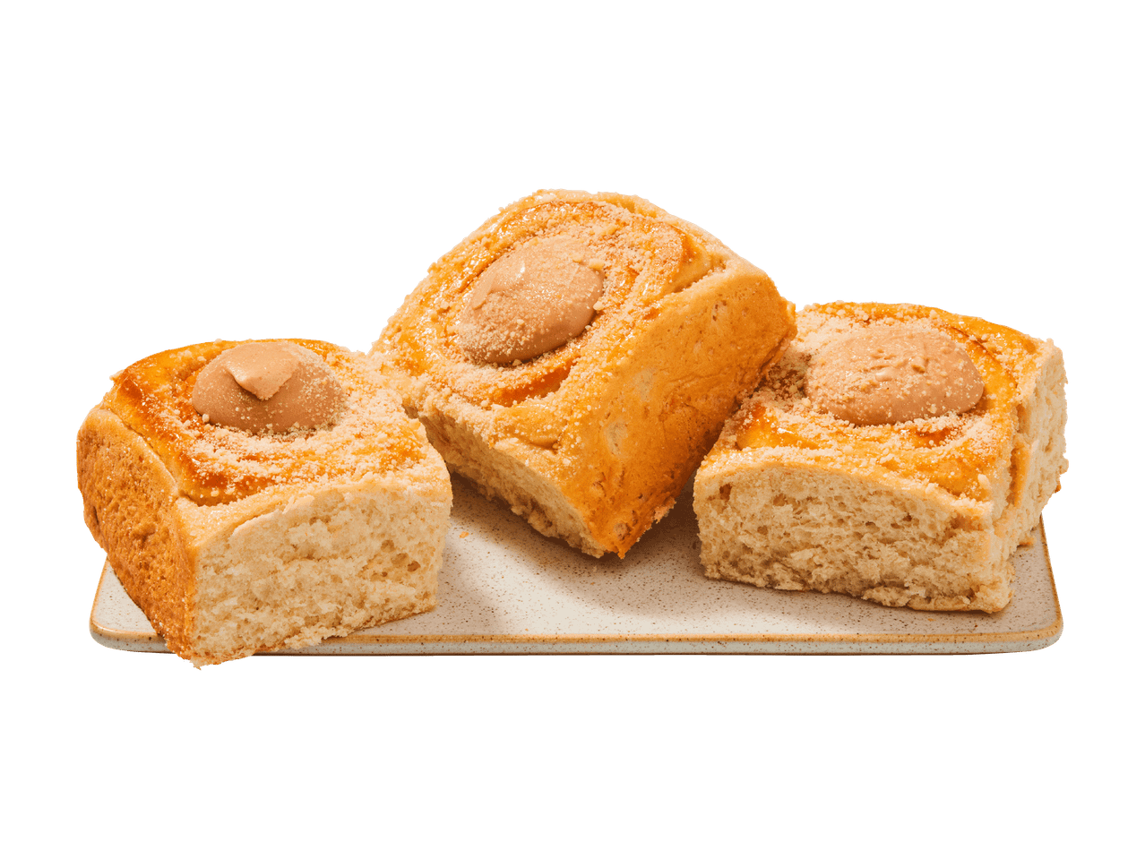 Trois brioches carrées sucrées avec glaçage et vermicelles, sur une assiette rectangulaire.