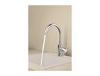 Chrome kitchen tap with water running into a light-colored sink.