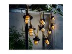 LIVARNO home Solar Flaming Lantern String Lights with plants in a dark setting.