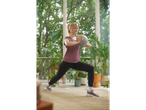 Woman in CRIVIT trainers and activewear doing lunges with a small ball.