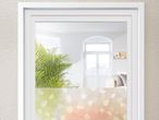 Fensterfolie mit dezentem, pastellfarbenem Blumenmuster in einem weißen Bilderrahmen.