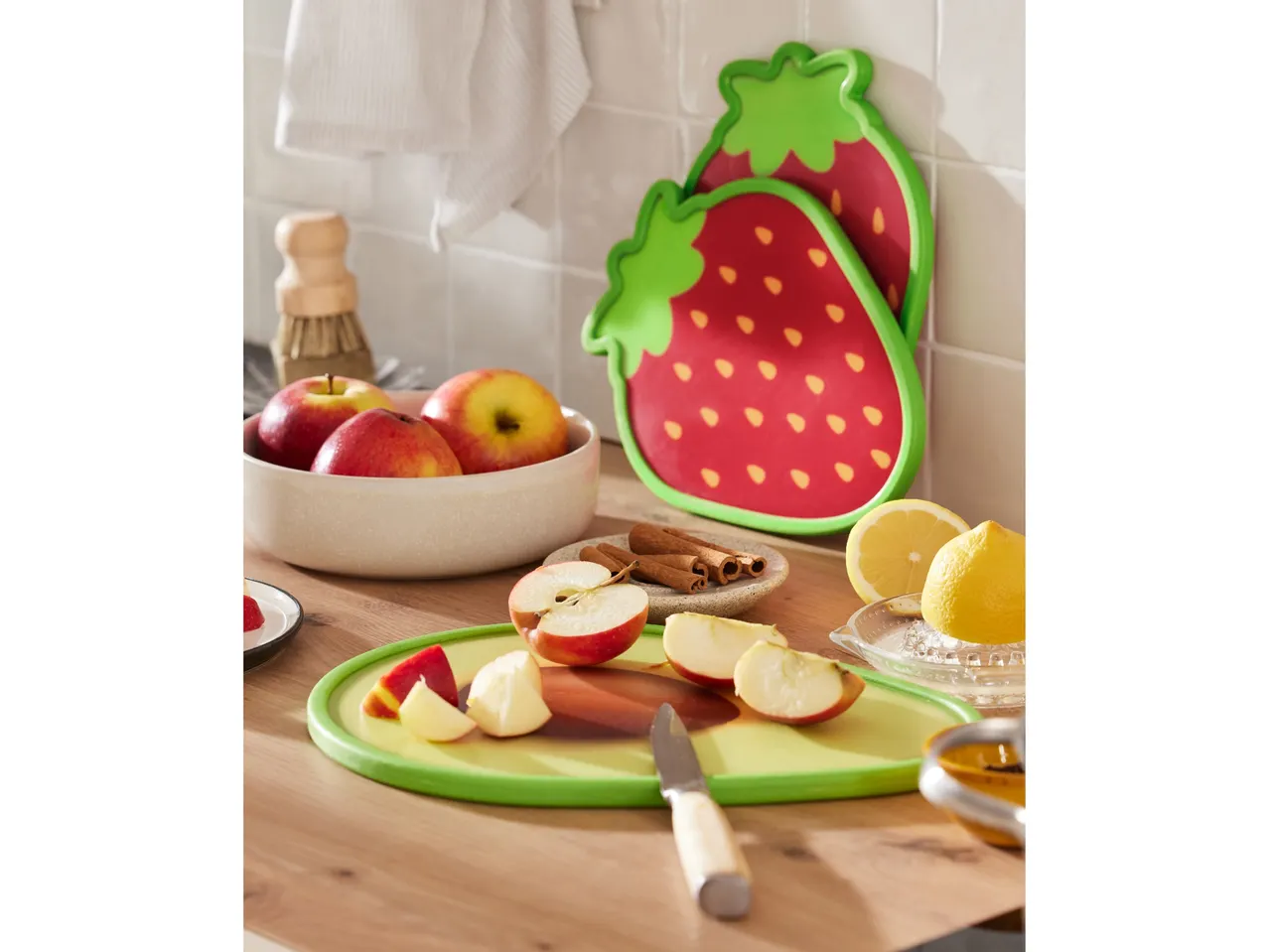 Taglieri a forma di fragola e avocado, su un tavolo da cucina.