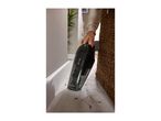 Handheld vacuum cleaner with 'WET + DRY' text, cleaning dirt from a tiled floor.