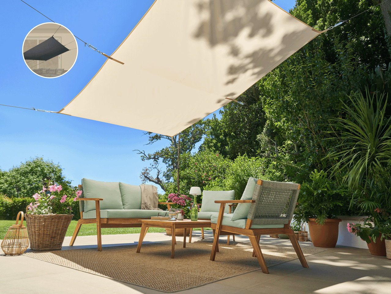 Zunanja sedežna garnitura s senčnim jadrom na terasi, obdana z zelenjem.