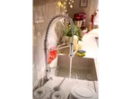 Baterie de bucătărie LIVARNO Viensvirtis cu apă curgătoare în chiuvetă, înconjurată de decorațiuni.