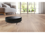 Robô aspirador Silvercrest® com função de esfregar num chão de madeira na sala de estar.