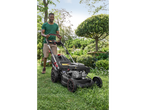 Man mowing lawn with a Parkside Performance® petrol lawnmower in a garden.
