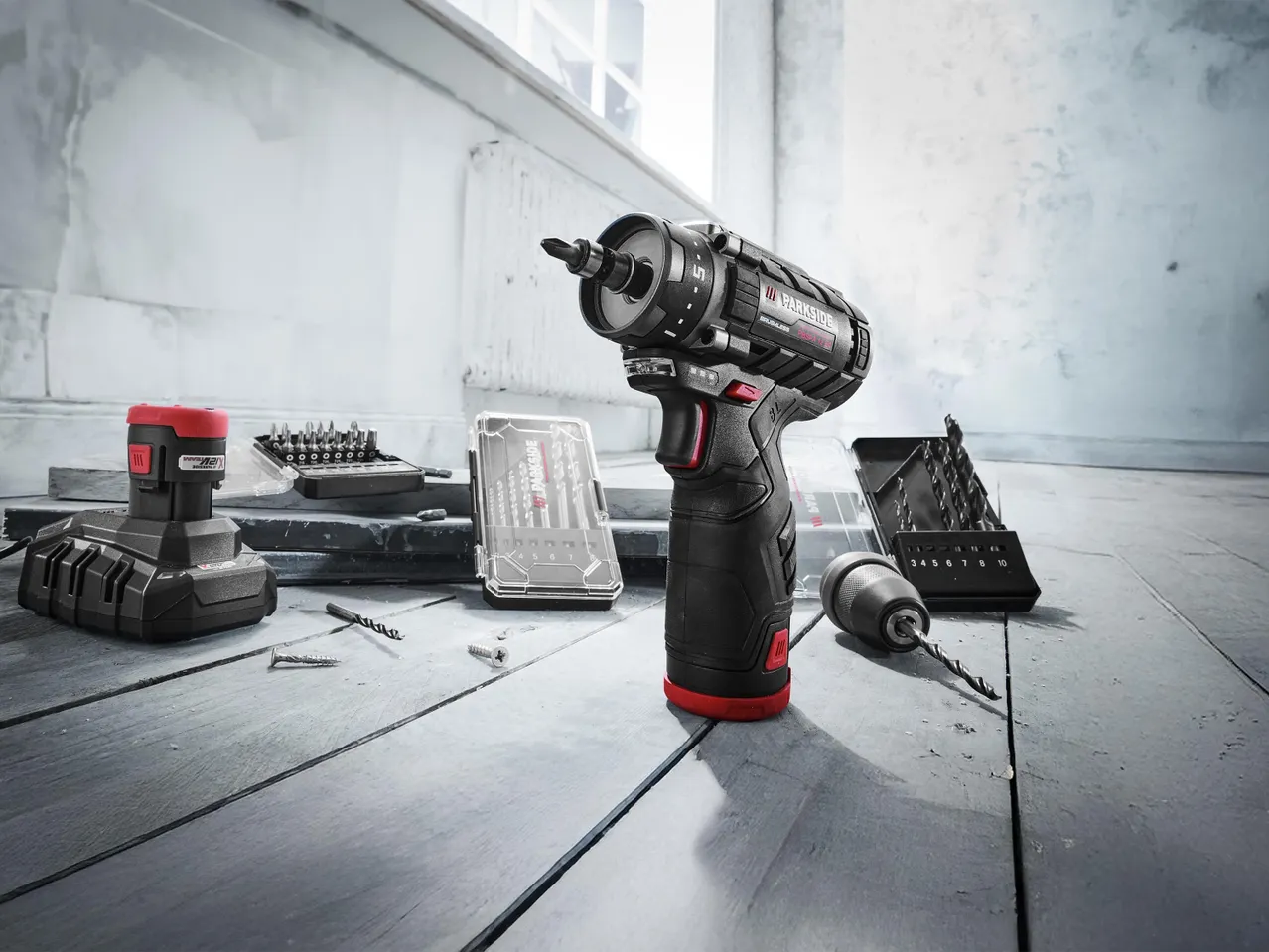 PARKSIDE akkus fúró-csavarozó, akkumulátor, töltő és fúrófej készletek egy szobában.