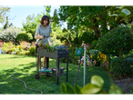 Woman watering plants in a raised garden bed with a Parkside Multi-Function Spray Gun.