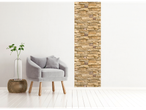 A modern living room with a grey armchair, a plant in a vase, and a stone accent wall.