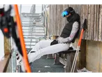 Woman in ski gear, including esmara® ski undershirt, sitting on a bench.