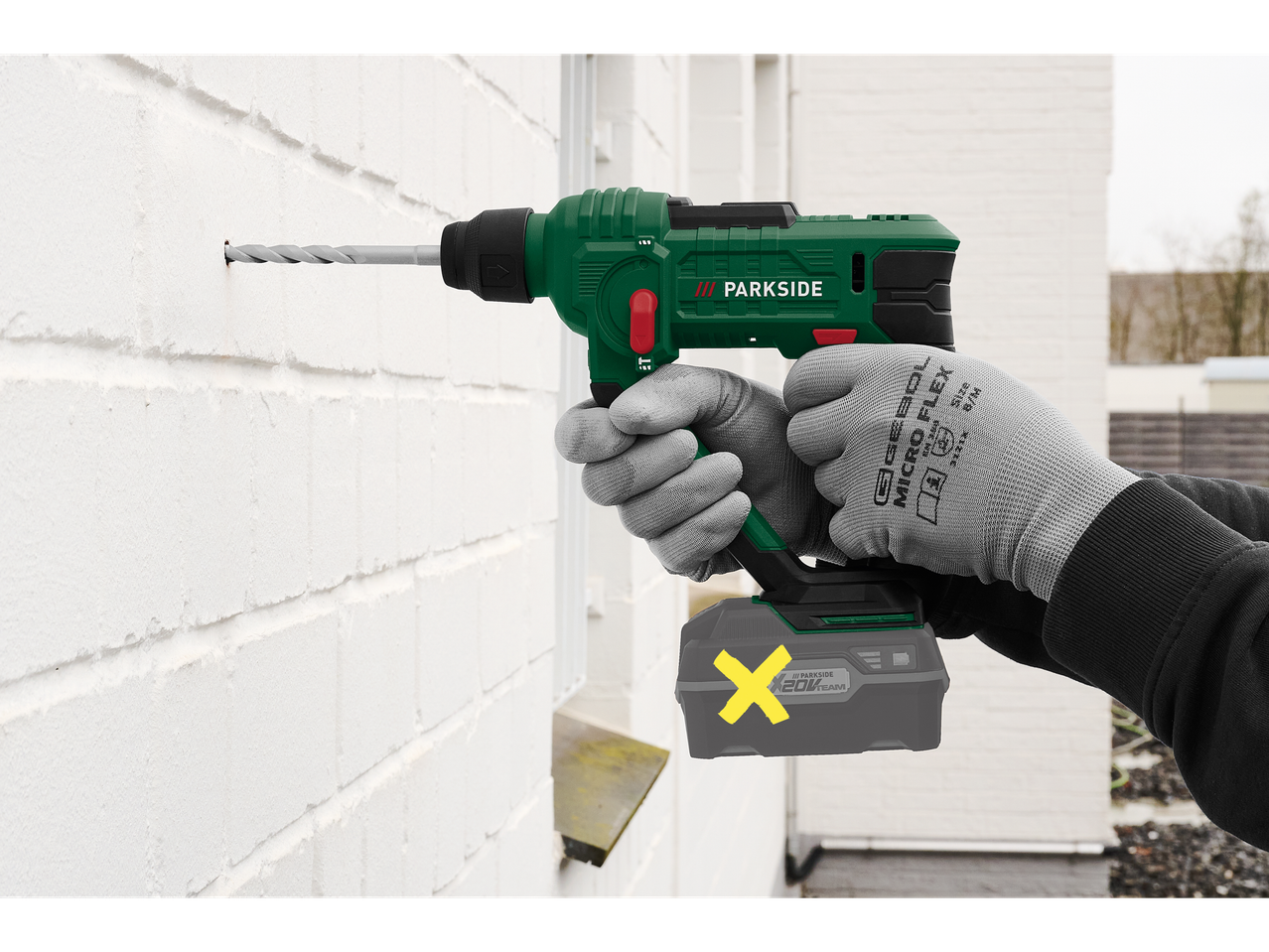 Parkside® akkumulátoros fúrókalapács fúr egy fehér téglafalba.