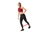 Ženska vadi z gumijastim trakom za fitnes.
