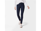 Woman wearing dark wash skinny jeans, a white ribbed sweater, and white sneakers.